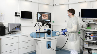 Junger Arzt übt am Endoskopie-Simulator das Durchführen einer Endoskopie.